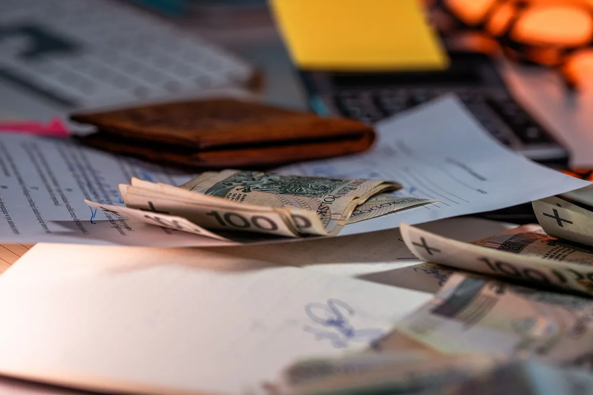 Étudiante analysant son budget sur un ordinateur portable avec des documents et une calculatrice