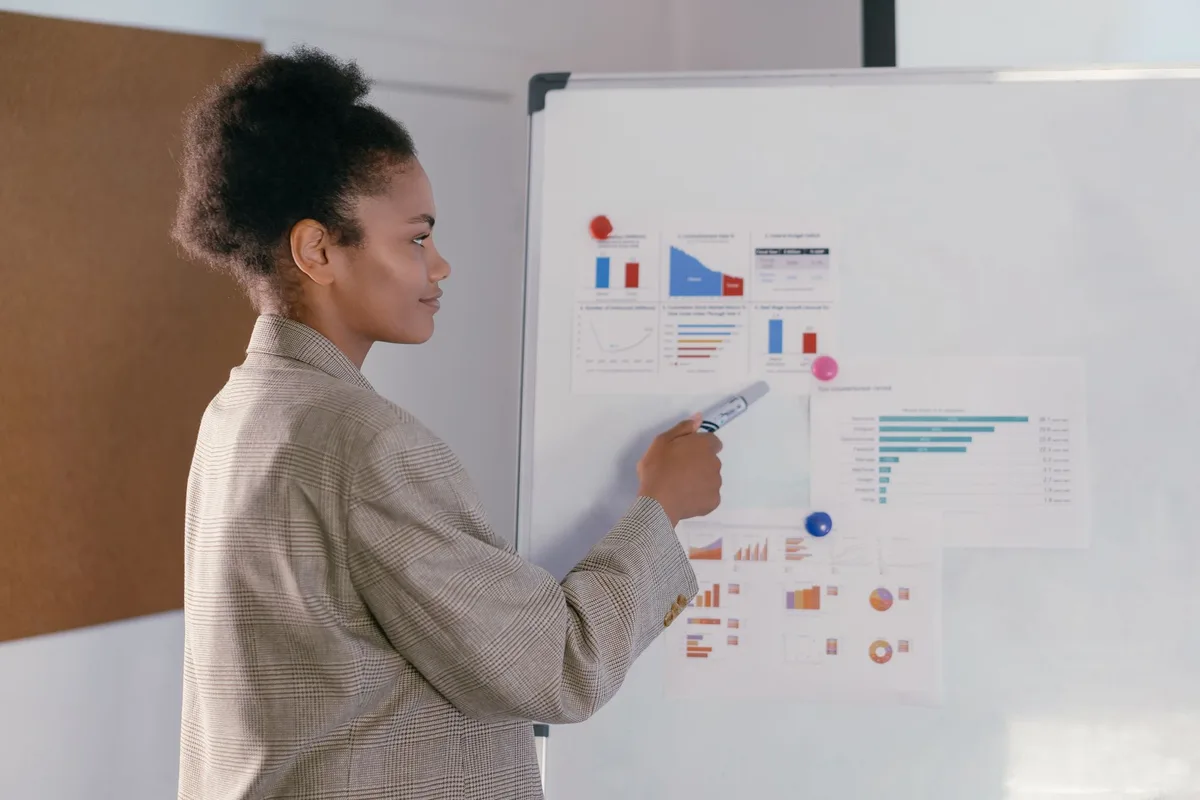 Deux personnes définissant ensemble des objectifs SMART clairs sur un tableau blanc.