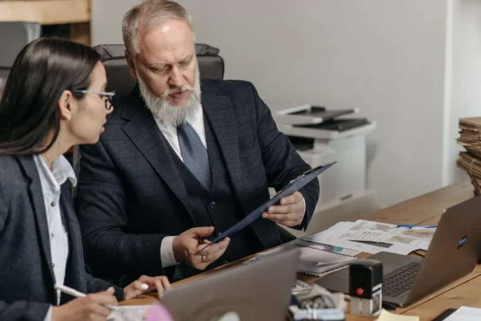 Deux professionnels en entretien d'évaluation, l'un écoutant activement tandis que l'autre s'exprime dans un cadre bienv