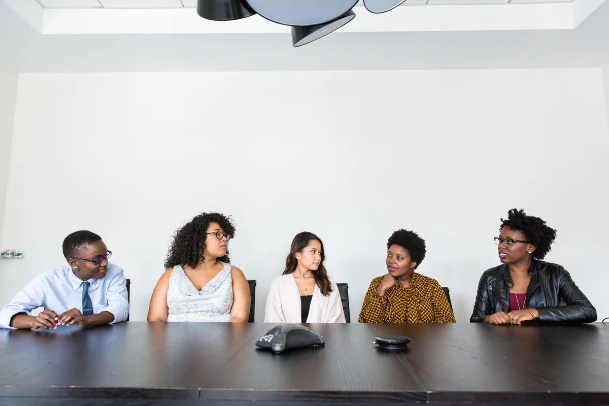 Équipe diversifiée réunie autour d'une table, échanges inclusifs et respectueux