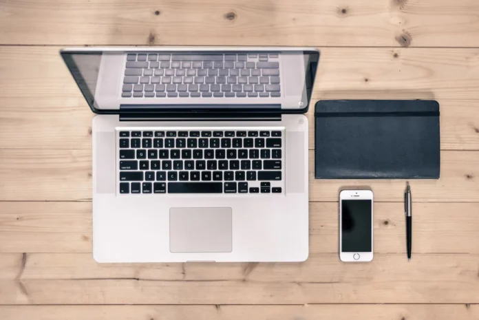Mains tapant sur un clavier pour enregistrer un nom de domaine sur un ordinateur portable