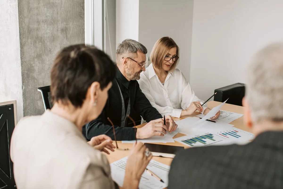 Équipe de vente, marketing et customer success réunie autour d'une table pour discuter des objectifs communs.