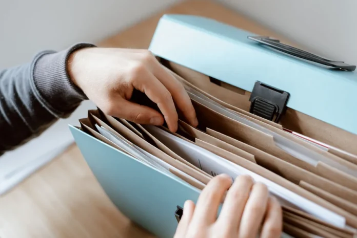 Documents administratifs et titres de séjour organisés sur un bureau avec des formulaires