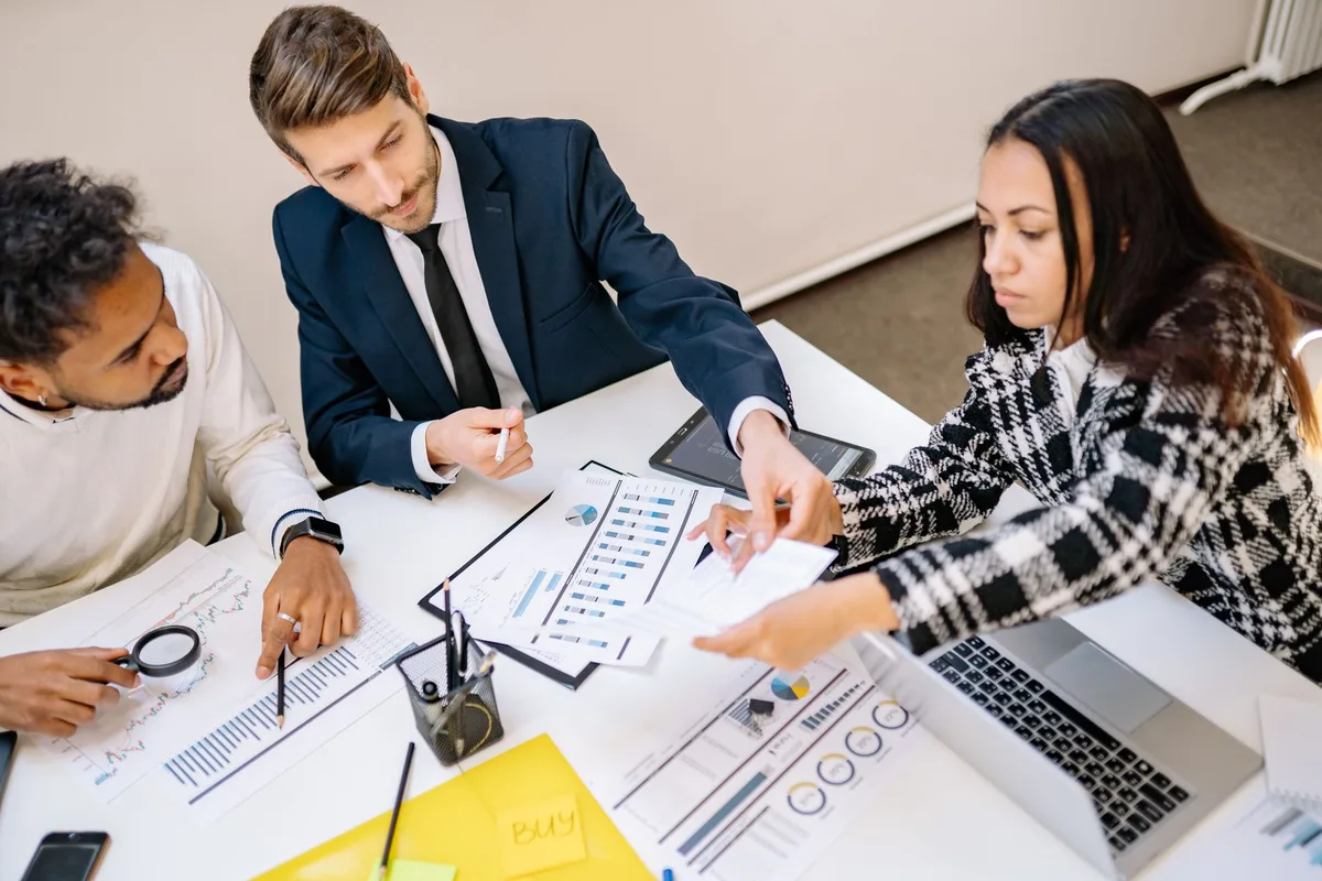 Équipe de professionnels discutant autour de graphiques et d'analyses de données