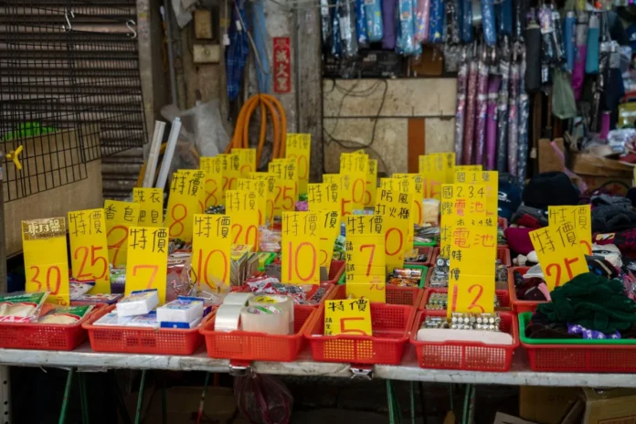 Mains organisant des étiquettes de prix et des produits sur des étagères de magasin avec des calculs de marge visibles