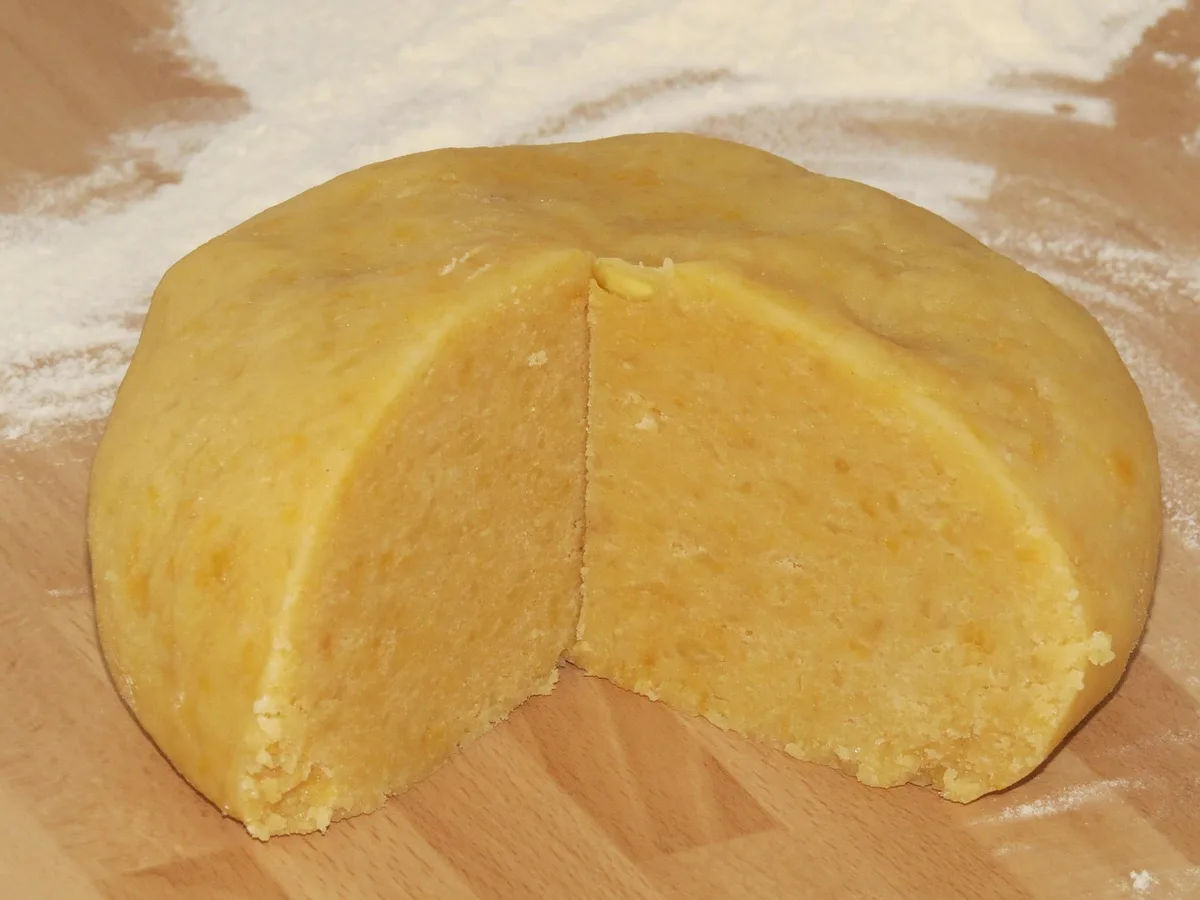 Mains travaillant une pâte dans un atelier de pâtisserie