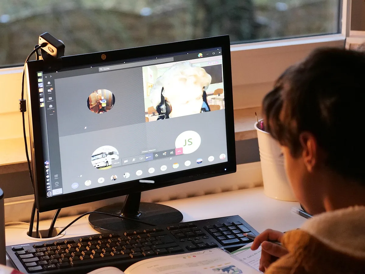 Personne suivant une formation en ligne sur ordinateur depuis son domicile