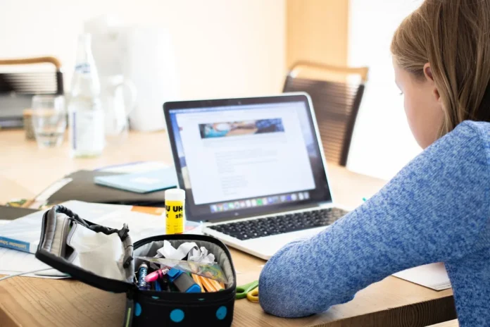Personne suivant un cours de langue en ligne sur son ordinateur portable avec écouteurs