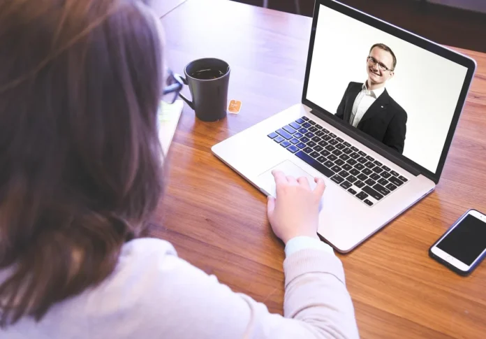 Mains d'une personne signant lors d'un appel vidéo en ligne pour une formation LSF