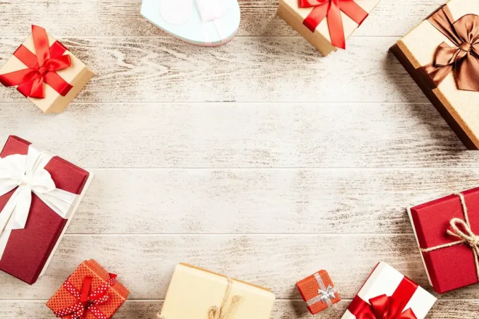 Mains arrangeant des produits artisanaux dans un coffret cadeau avec papier de soie et détails de présentation