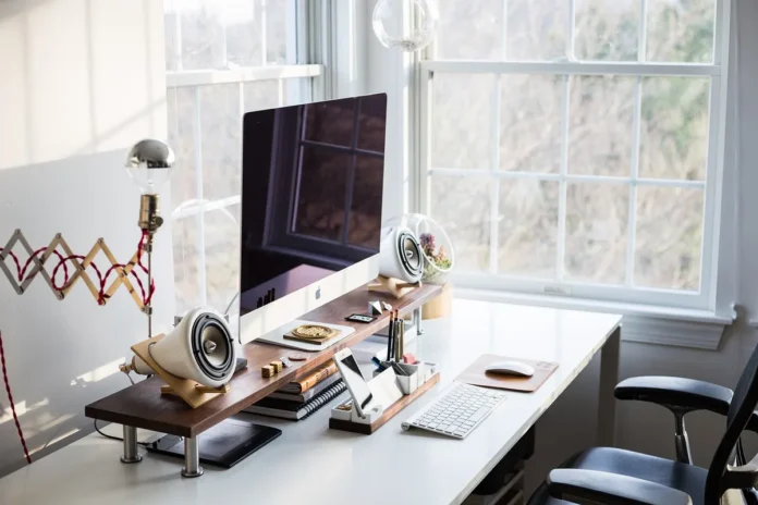 Bureau clair avec table, dossiers ouverts et chaises près d'une fenêtre en plein jour