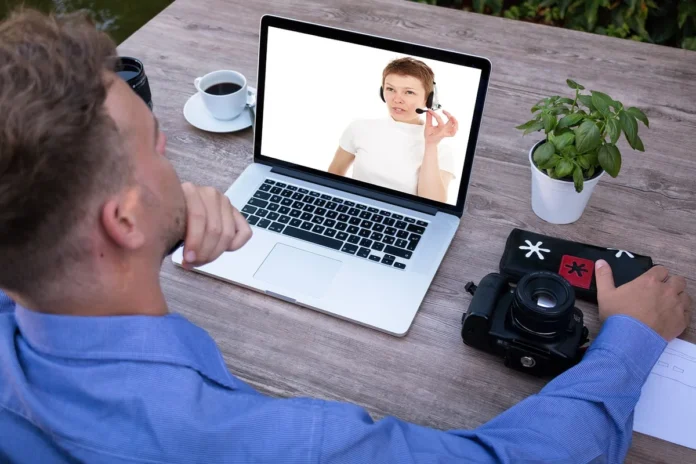 Personne anonyme de dos devant un ordinateur pour une session d'apprentissage en ligne