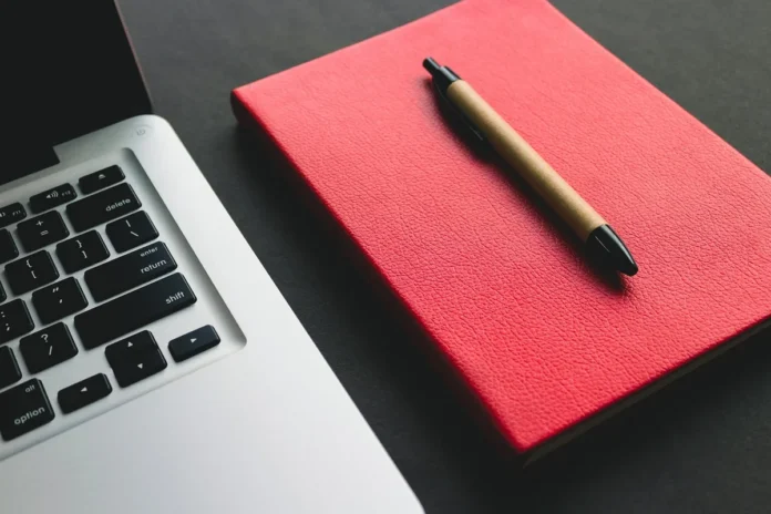 Bureau lumineux avec ordinateur portable, composant matériel et bloc-notes près d'une fenêtre