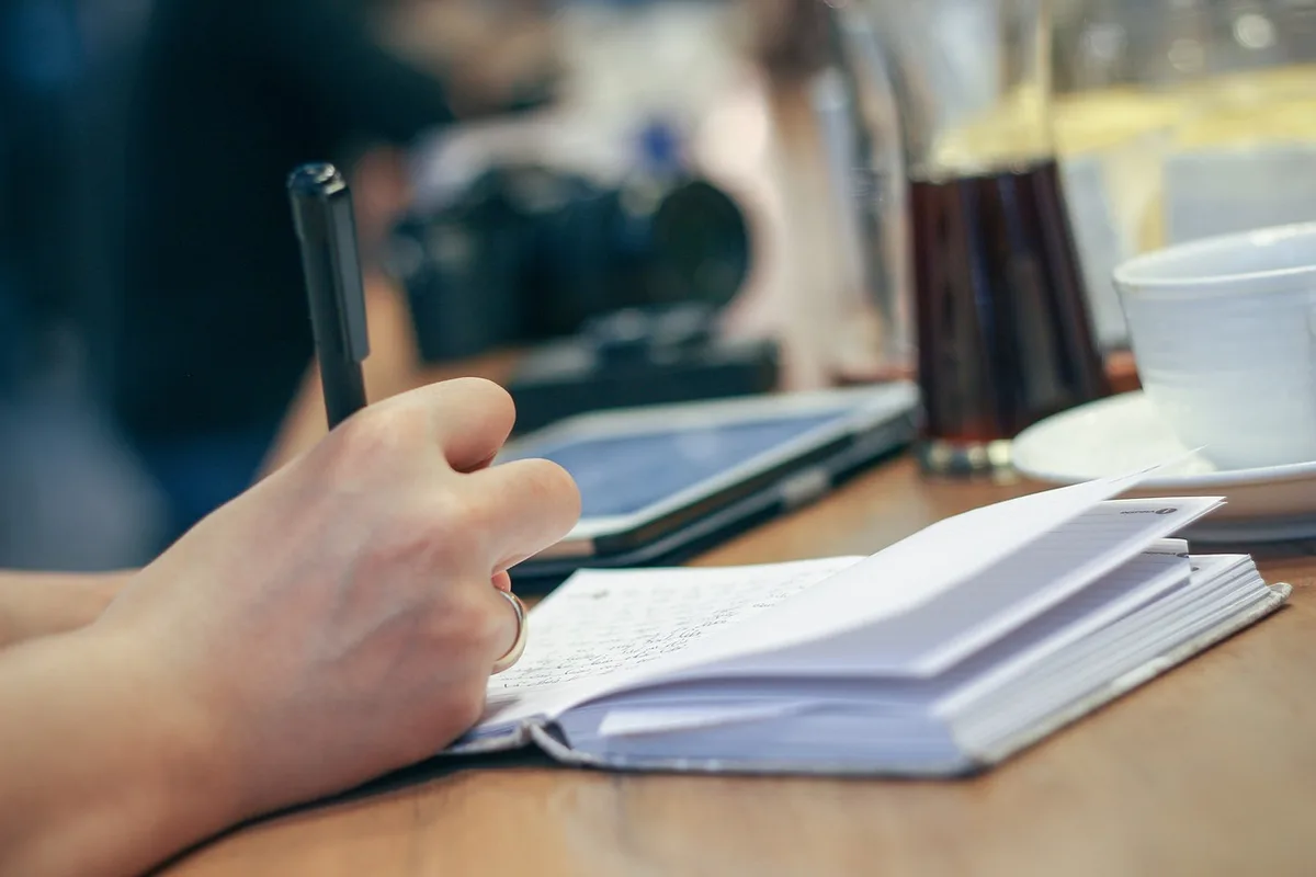 Carnet ouvert et stylo sur un bureau montrant des notes marketing