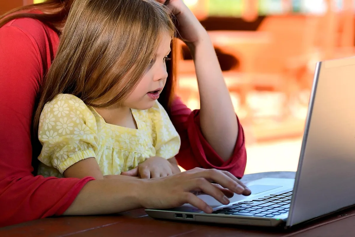 Personne suivant une formation en ligne sur son ordinateur depuis son domicile