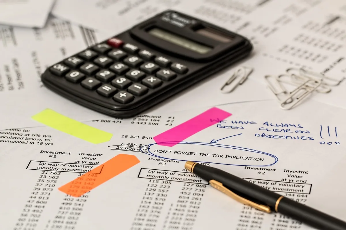 Calculatrice et feuille de calcul sur un bureau pour estimer le montant net d'une indemnité