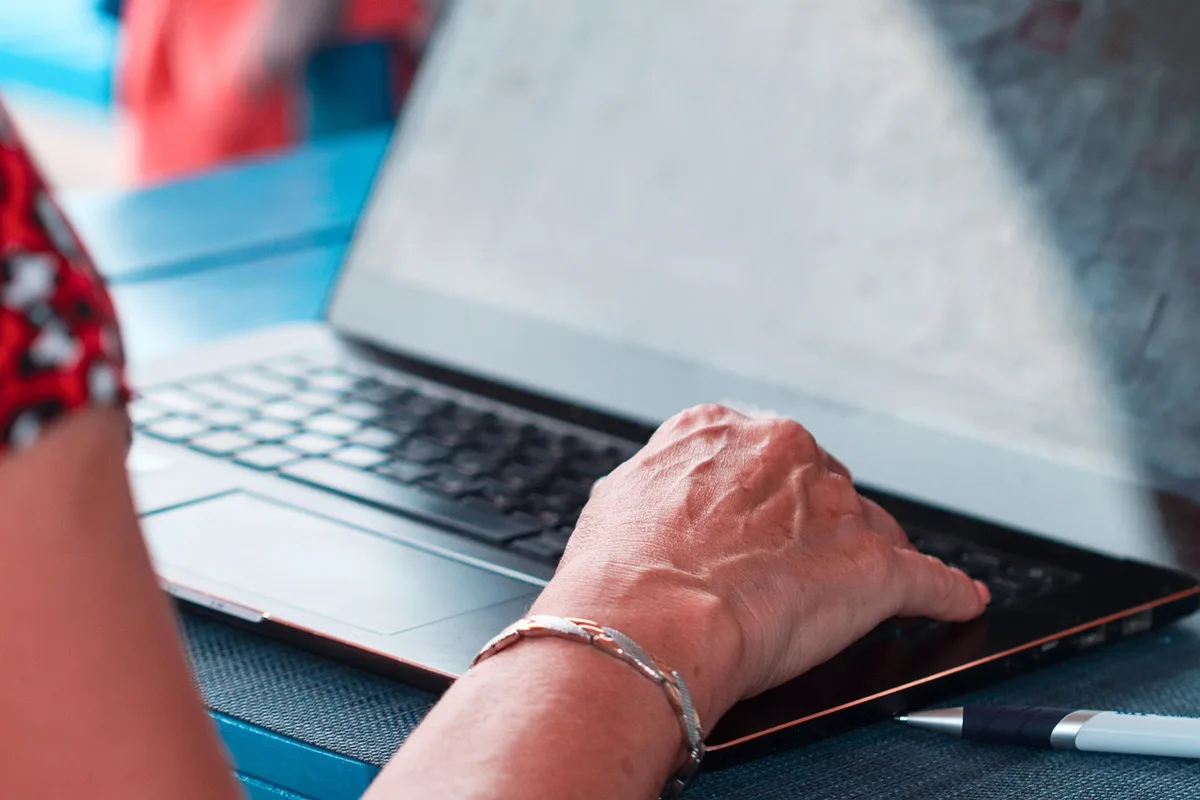Personne travaillant à domicile avec ordinateur et notes pour communication asynchrone