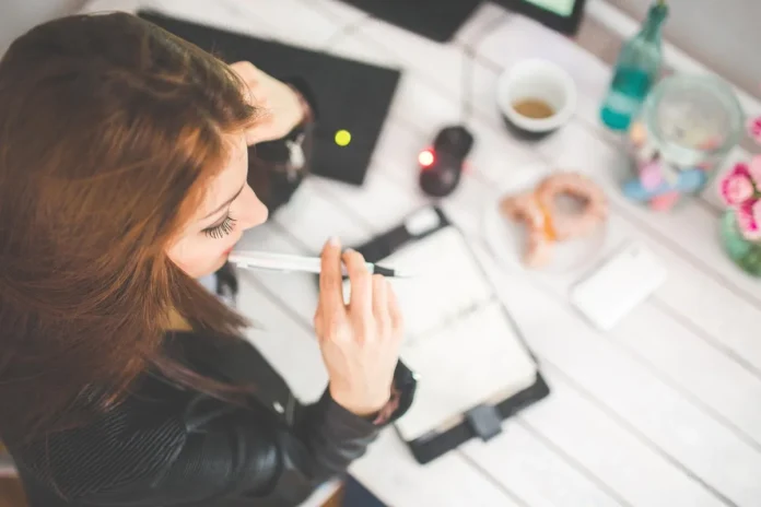 Équipe en bureau lumineux travaillant sur des prompts IA avec ordinateur et carnet