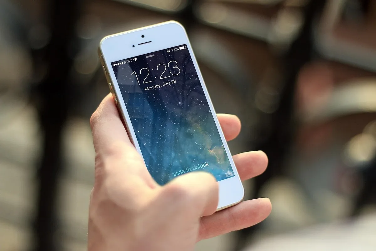 Client payant avec un smartphone devant un terminal sans contact au comptoir