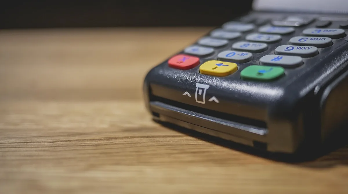 Technicien configurant un terminal de paiement sur un comptoir de magasin
