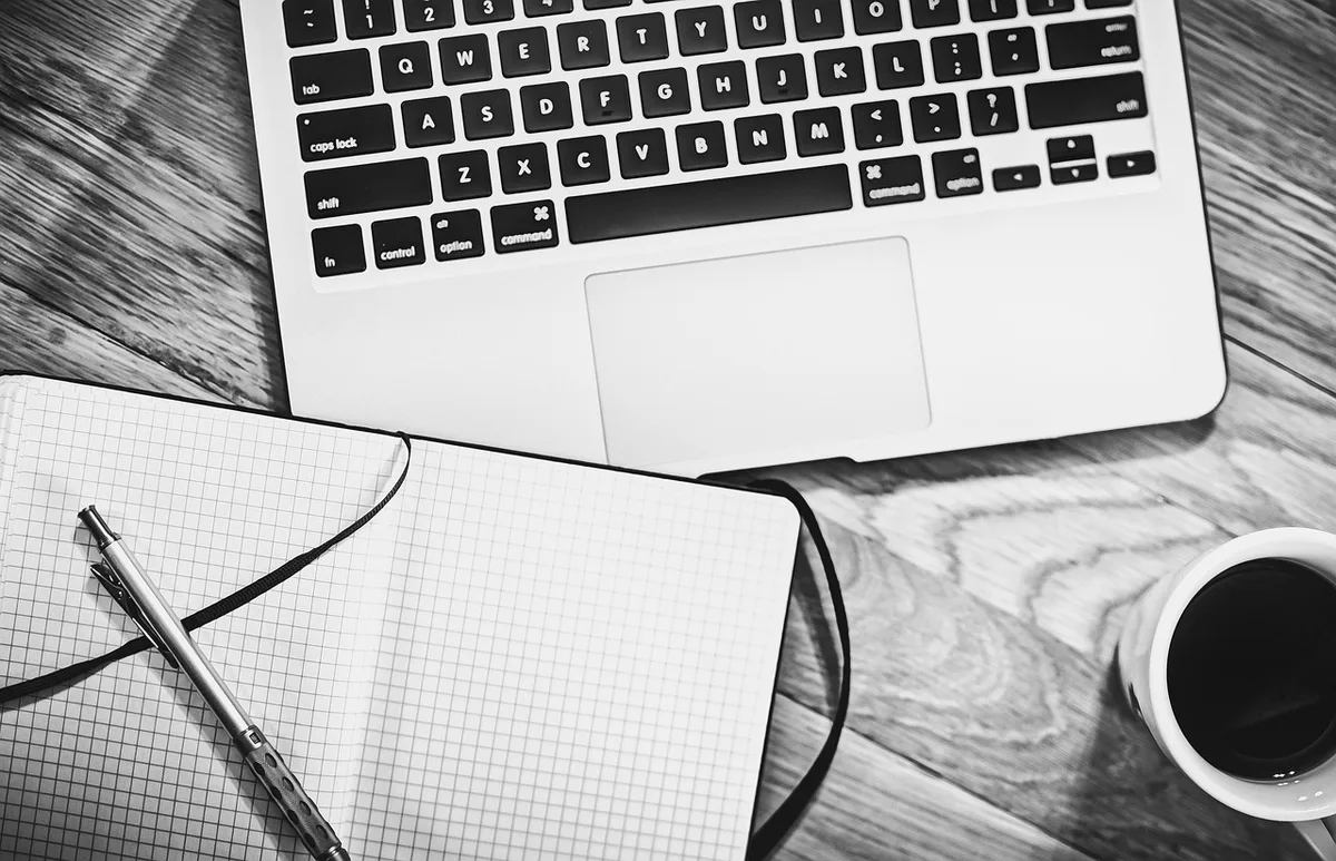 Auteur prenant des notes et planifiant le projet d'impression sur un bureau