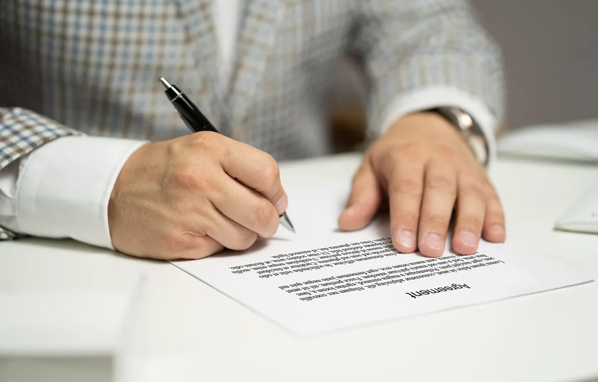 Mandat écrit et contrat de commission posé sur un bureau