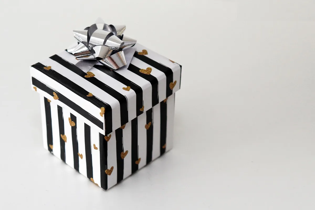 Main ouvrant une boîte de bijoux avec packaging soigné
