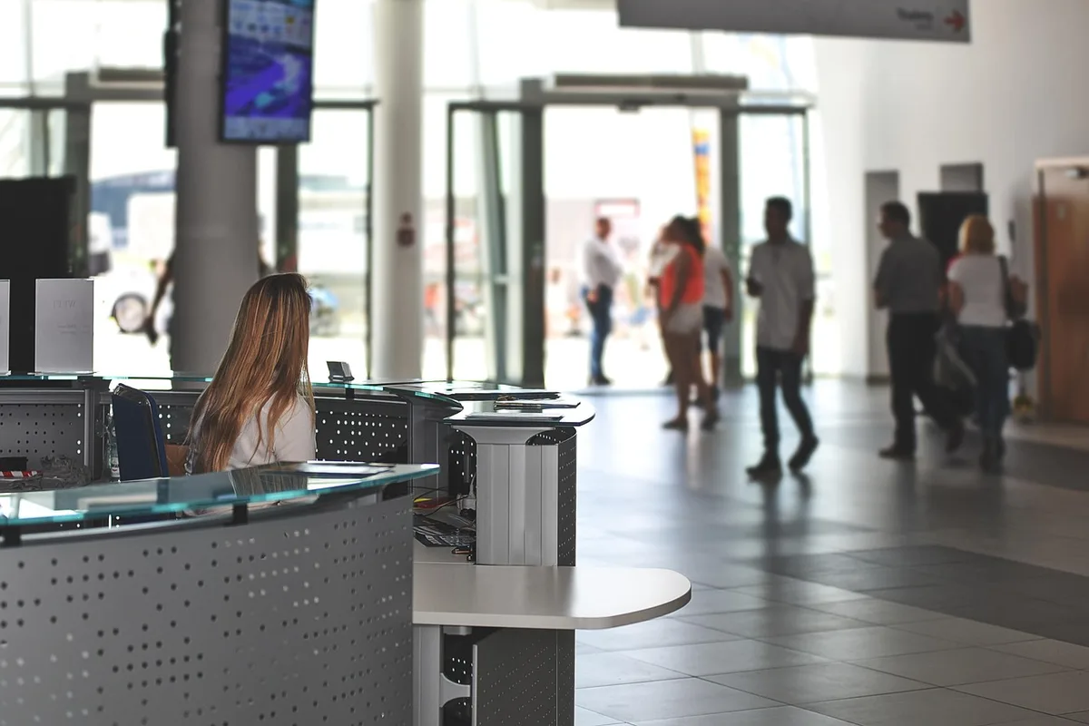 Main d'un collaborateur décrochant un téléphone sur un bureau professionnel
