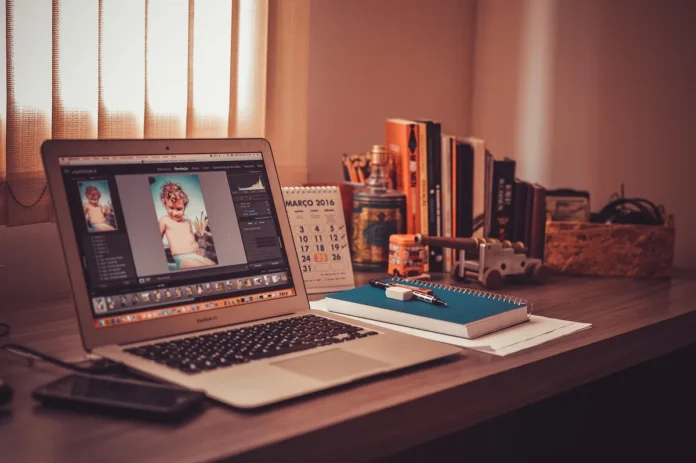 Bureau lumineux près d'une fenêtre avec ordinateur, carnet et checklist pour lancer une idée secondaire