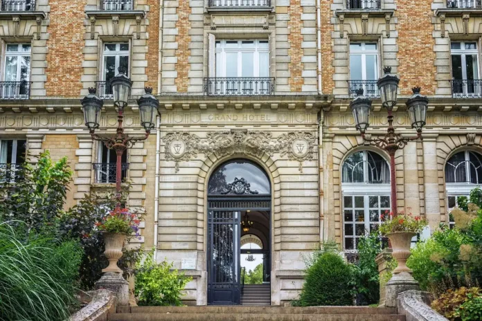 Accueil hôtelier en journée avec mains échangeant un CV près d'un comptoir