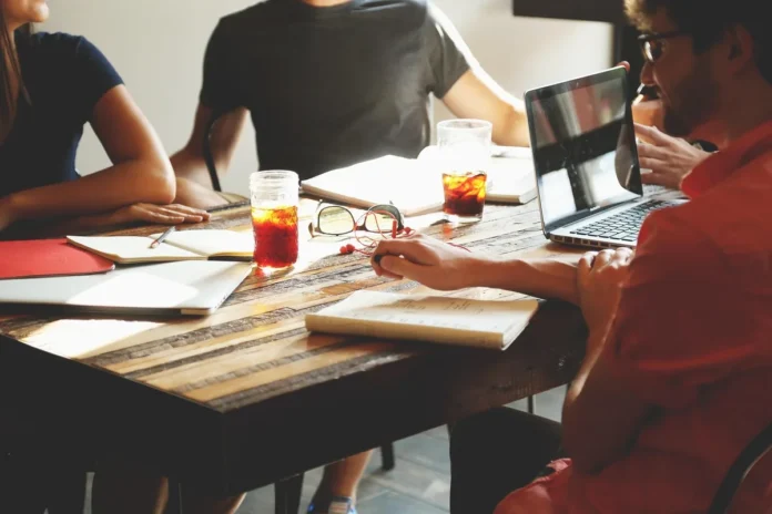 Bureau lumineux avec table de réunion, dossiers et mains échangeant des notes