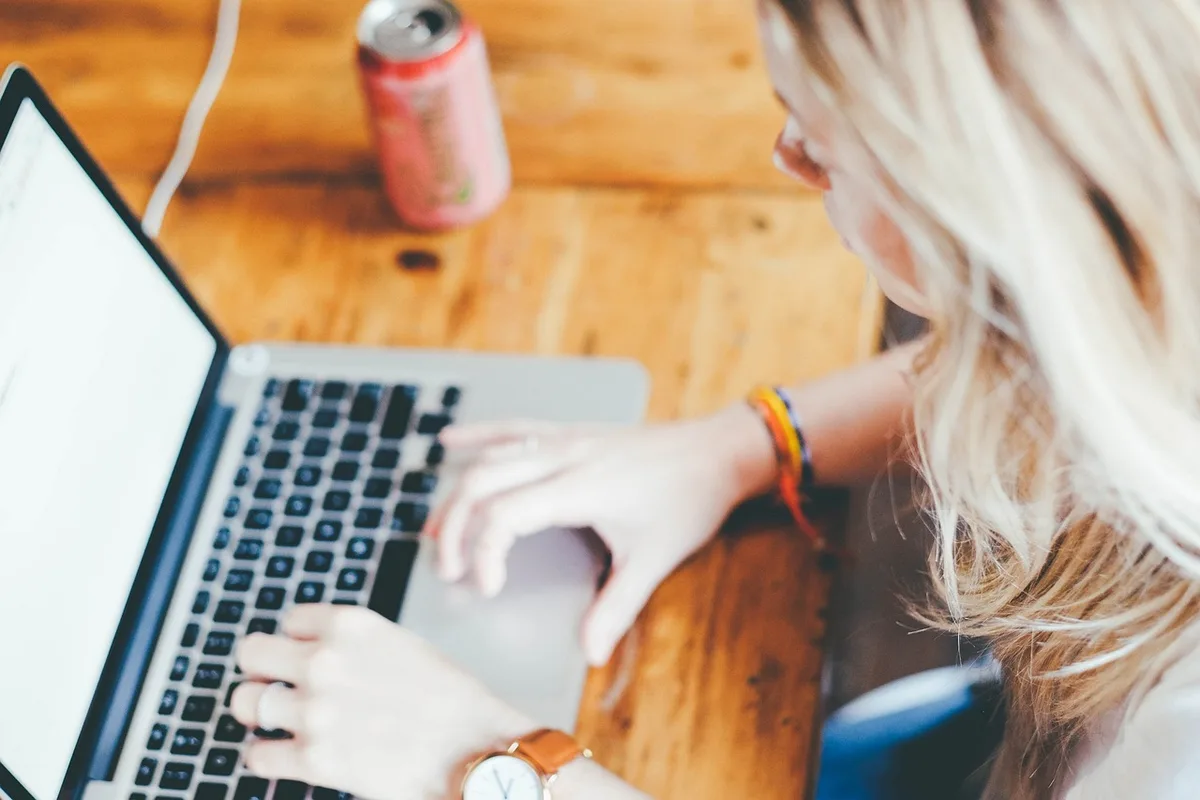 Personne suivant une formation en ligne sur un ordinateur portable à la maison