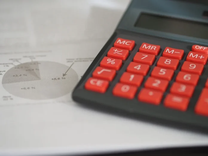 Bureau de notaire en journée avec documents et calculatrice sur la table