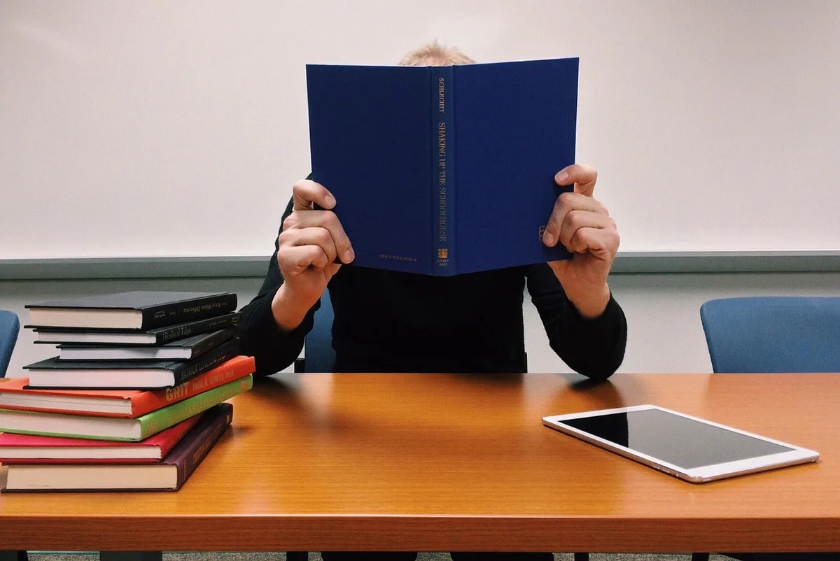 Ordinateur portable avec tableur affiché et carnet de notes à côté