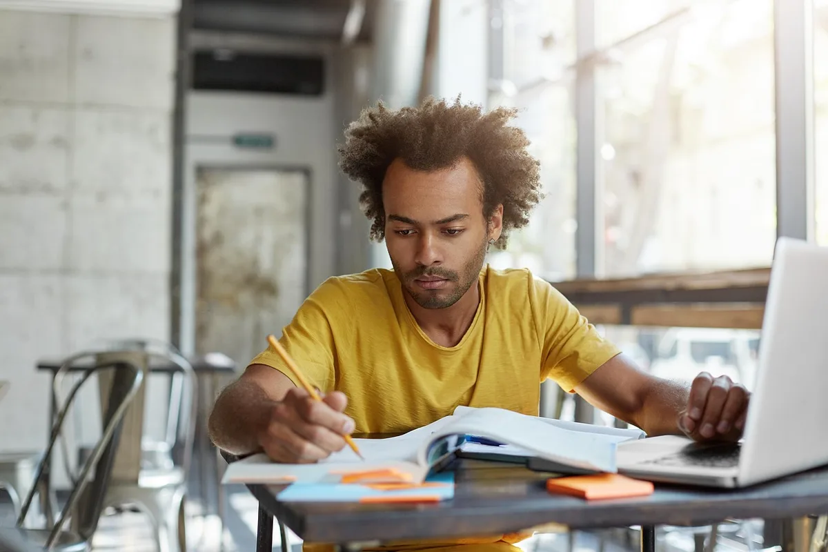 Étudiant en train de réviser avec un minuteur sur le bureau