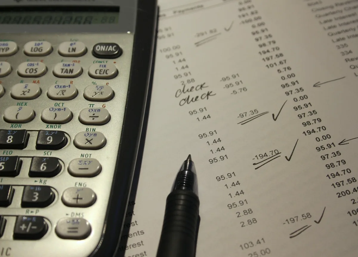 Documents de prêt et calculatrice sur un bureau, illustrant le calcul du coût réel