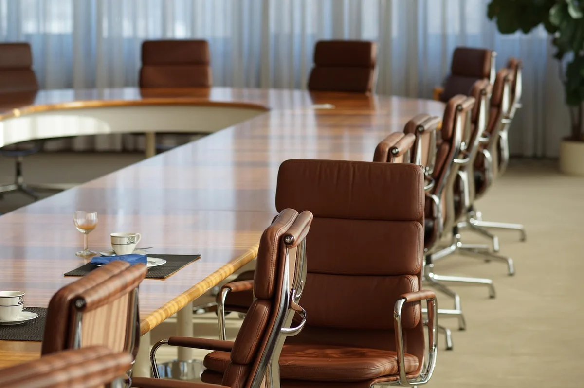 Deux collègues discutant autour d'une table de réunion en journée